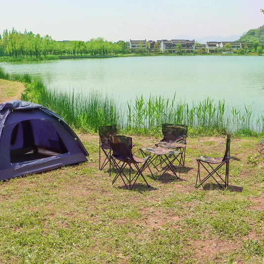 Camping setup with a tent and chairs by a lake