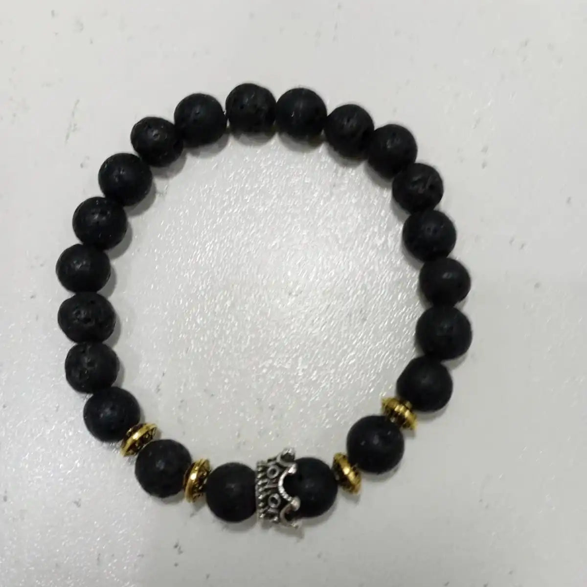 Handmade genuine volcanic rock bracelet with a royal crown symbol for strength and empowerment.
