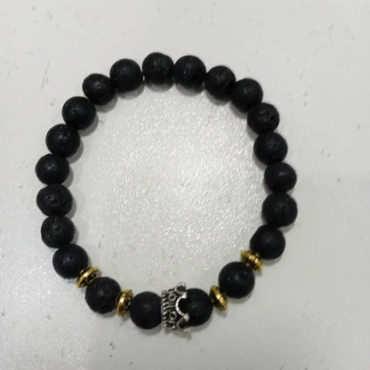Handmade genuine volcanic rock bracelet with a royal crown symbol for strength and empowerment.
