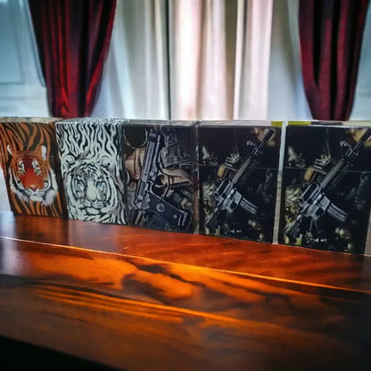 Pop open Cigarette case with tigers and weapon printed on it on a table