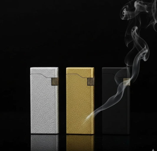 Three metallic lighters in silver, gold, and black on a textured surface