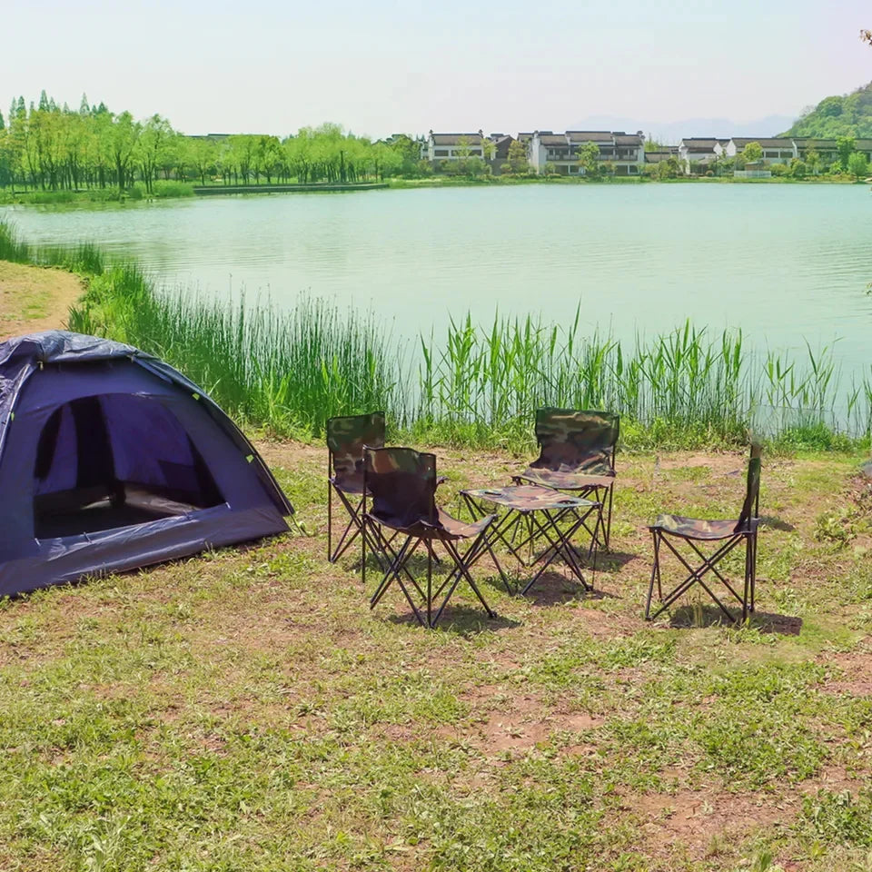 Camping setup with a tent and chairs by a lake