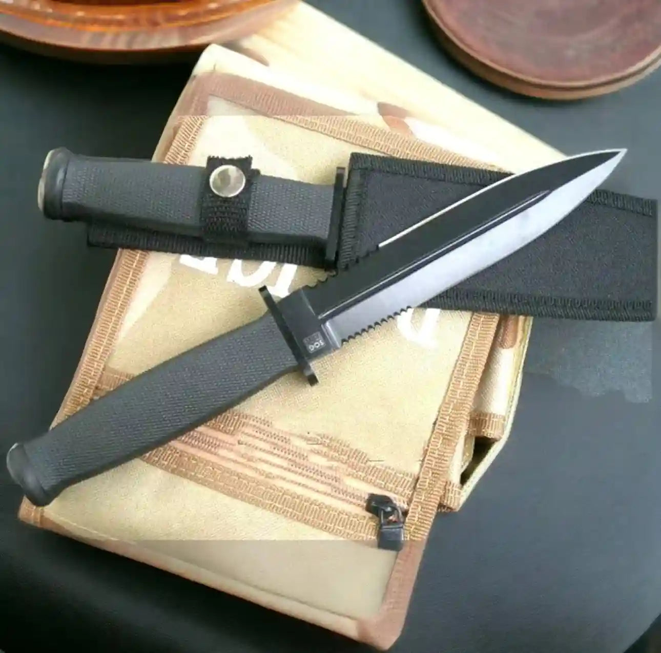 Knife with black sheath on a textured surface