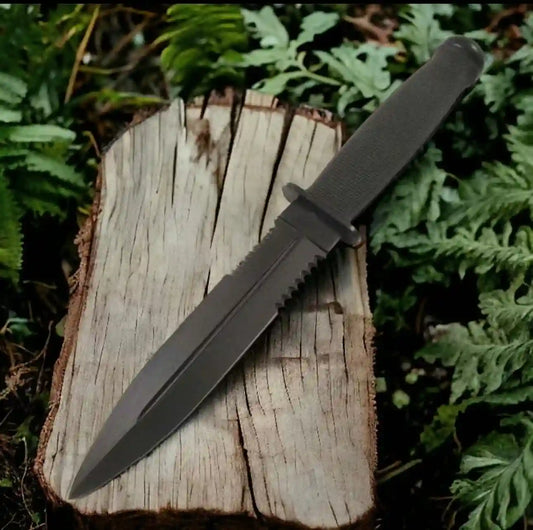 Black knife on a wooden log with green foliage in the background